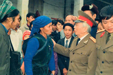 Bà Dương Thị Hỷ địu cháu trên lưng, đứng trò chuyện với Đại tướng Võ Nguyên Giáp năm 1994.