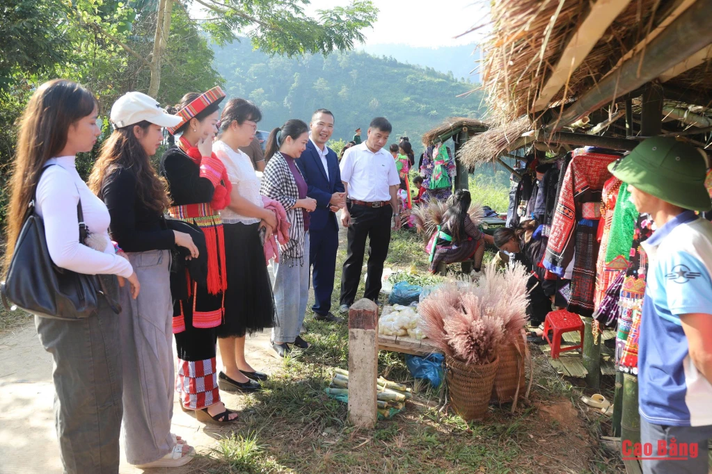 Lãnh đạo xã Pu Nhi giới thiệu các sản phẩm trưng bày tại gian hàng địa phương. 